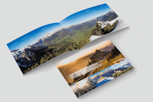 Doppeltes geöffnetes Broschüren- oder Magazin-Layout mit Landschaftsfotografien der Berge, Täler, Häuser und Sonnenuntergänge, mit Beschriftungen in deutscher Sprache.