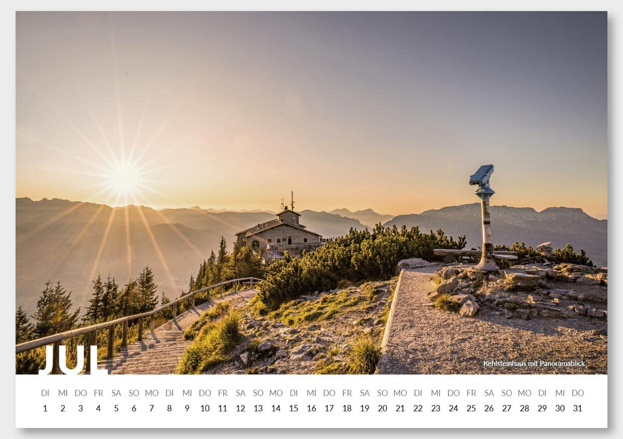 Ein Sonnenuntergang über Bergen mit einem Pfad, eine Wetterstation und einem Gebäude auf einem Hügel, im Juni-Kalender. Die Landschaft ist von Nadelbäumen geprägt, und es gibt einen Panoramakameras an einem Pfosten. Der Himmel ist nahezu klar mit sanften Farbverläufen.